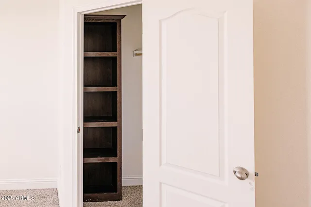 a view of empty room with closet and cabinet
