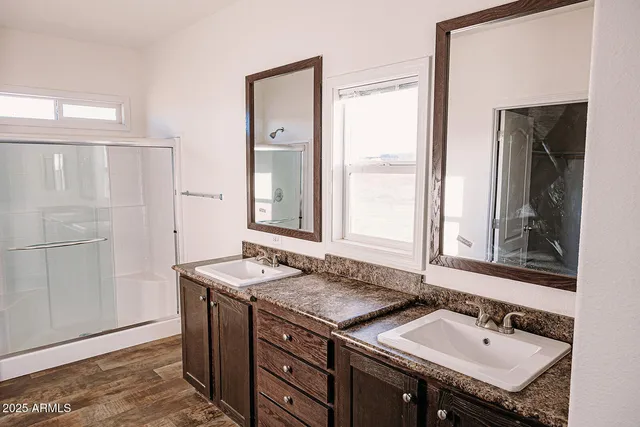 a bathroom with a granite countertop shower and a sink