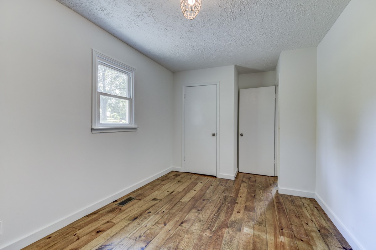 341 Lee Road Cottontown, TN 37048 - Photo 26 of 43 an empty room with wooden floor and windows