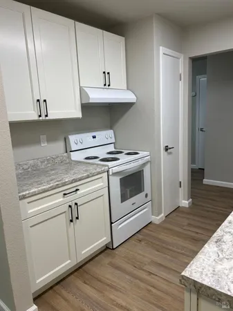 a kitchen with granite countertop white cabinets and white appliances