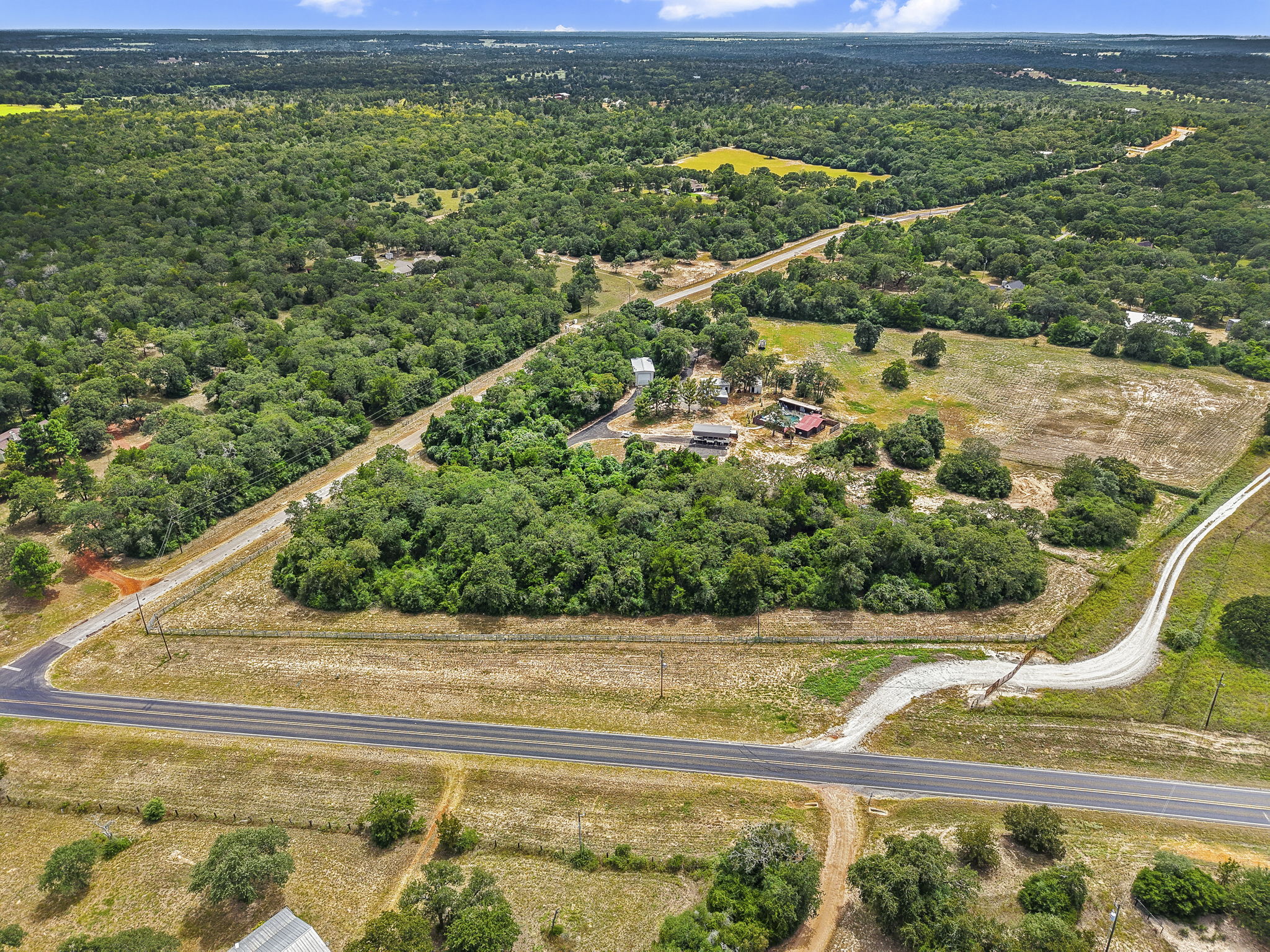 206 22 Hills Road Gause, TX 77857 - Photo 25 of 28 Lush woodlands and open pastures frame this expansive countryside acreage with multiple outbuildings.