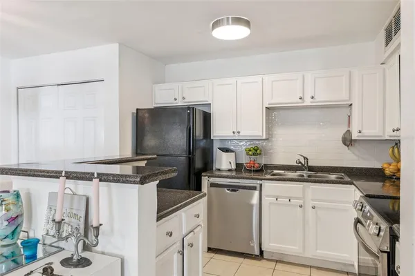 a kitchen with stainless steel appliances a sink a stove a refrigerator and cabinets