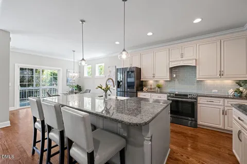 a kitchen with granite countertop kitchen island wooden cabinets and stainless steel appliances
