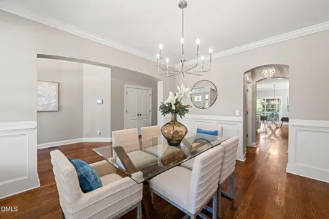 a view of a dining room with furniture a chandelier and wooden floor