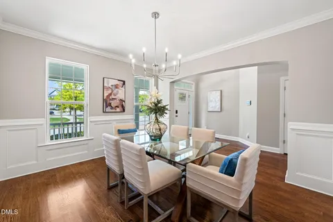 a view of a dining room with furniture a chandelier and wooden floor