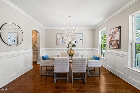 a dining room with furniture a chandelier and wooden floor