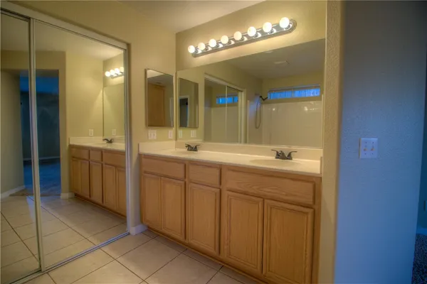 a spacious bathroom with a double vanity sink and a mirror