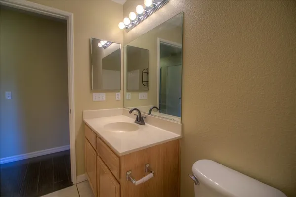 a bathroom with a sink a toilet and mirror