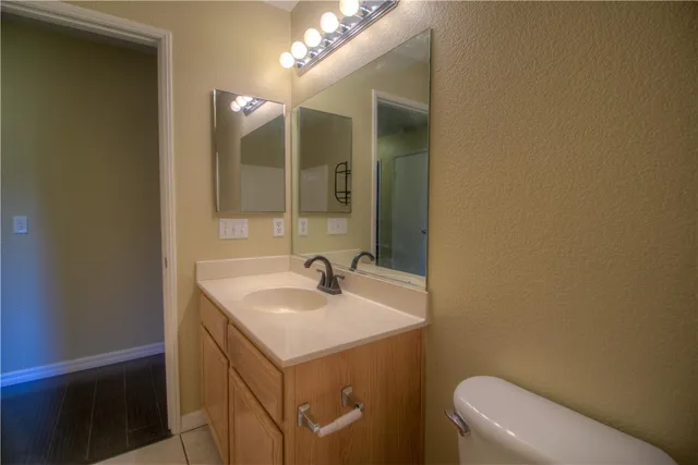 a bathroom with a sink a toilet and mirror