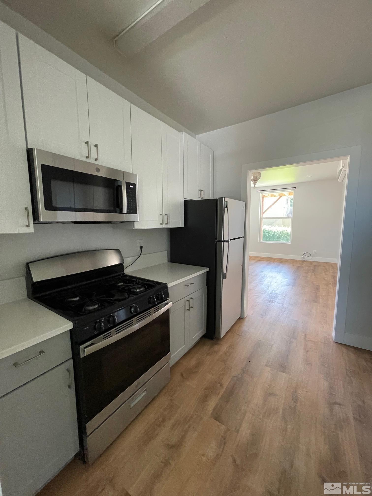 606 East 7th Street Reno, NV 89512 - Photo 13 of 35 a kitchen with granite countertop white cabinets and stainless steel appliances