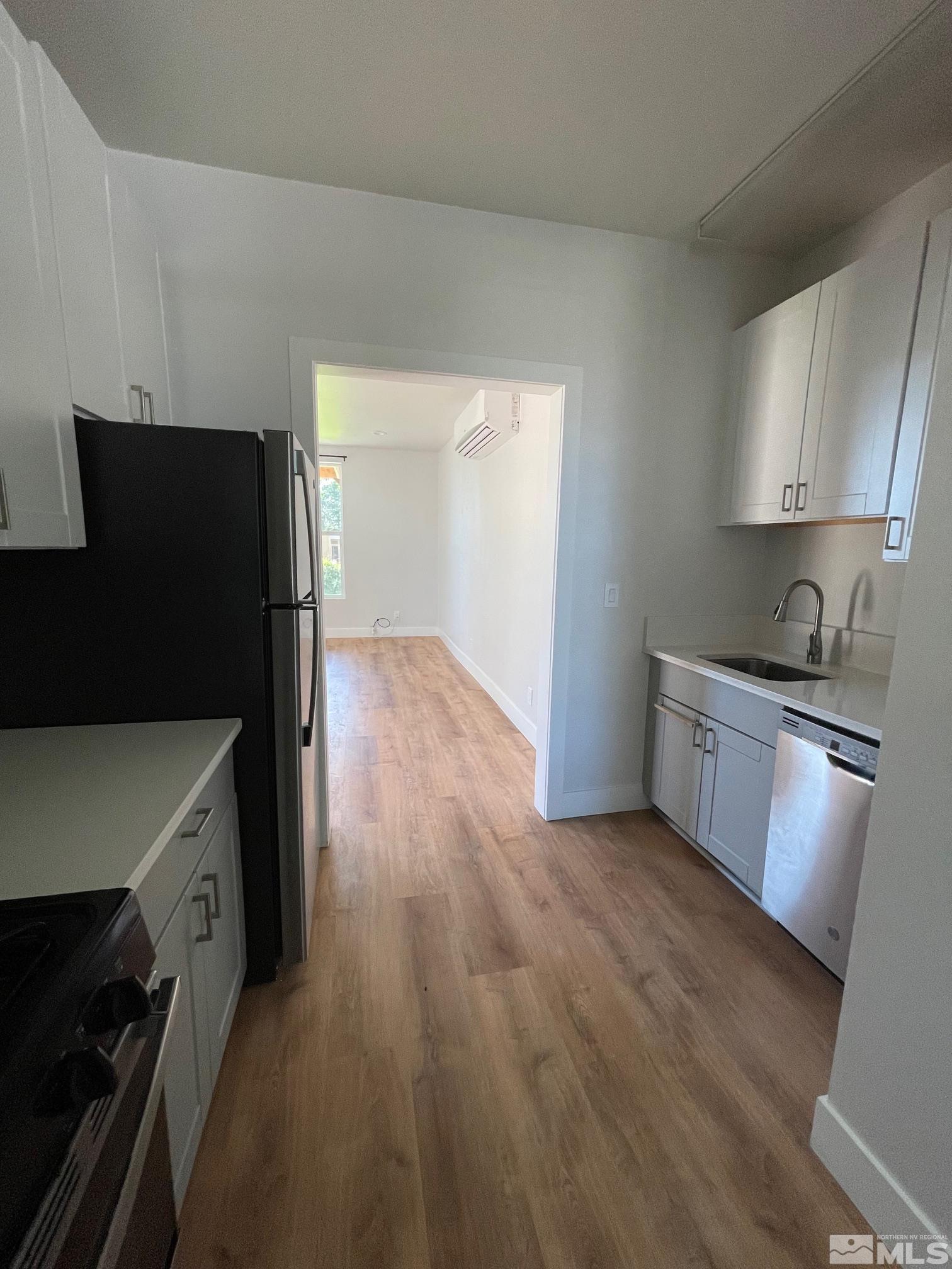 606 East 7th Street Reno, NV 89512 - Photo 15 of 35 a kitchen with granite countertop a refrigerator a stove and wooden floor