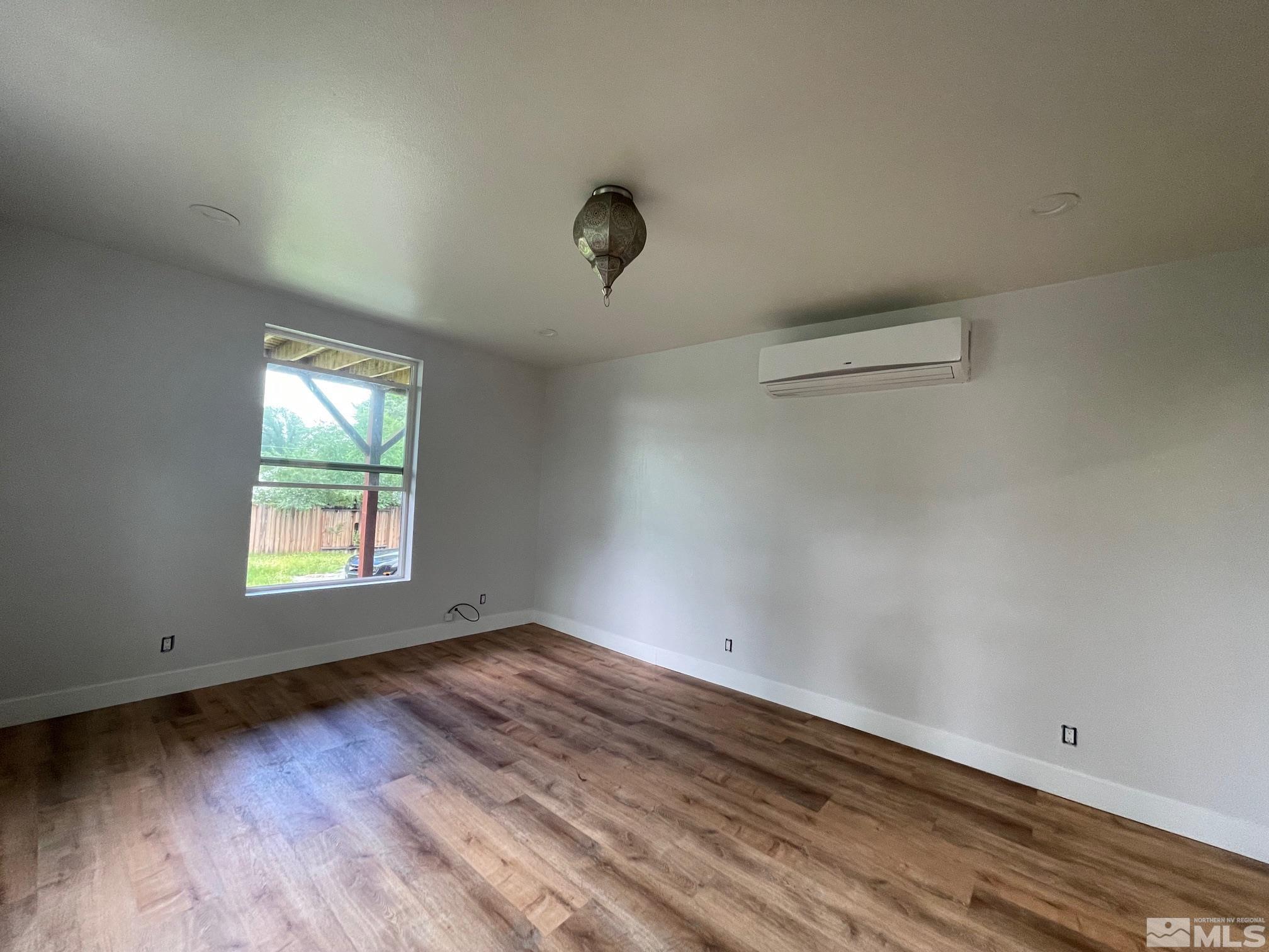 606 East 7th Street Reno, NV 89512 - Photo 19 of 35 an empty room with wooden floor and windows
