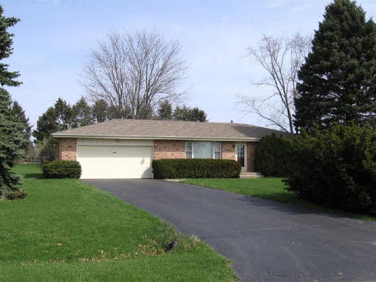 6891 Tipple Road Rockford, IL 61102 - Photo 1 of 6 a front view of a house with a yard and garage