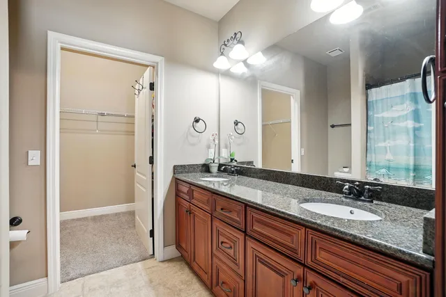 a bathroom with a granite countertop sink double vanity and a mirror
