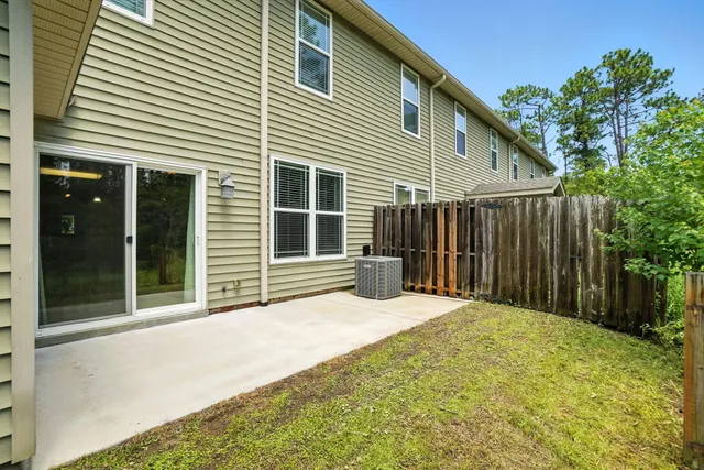 a view of backyard with large trees and wooden fence