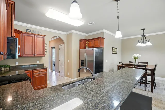 a kitchen with stainless steel appliances granite countertop a stove a sink and a refrigerator