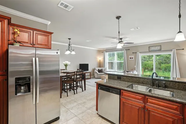 a kitchen with granite countertop a sink and refrigerator