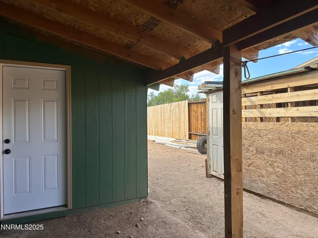 a view of a porch with a table and chairs in front of door