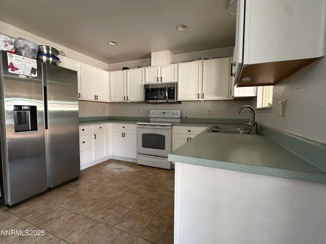 a kitchen with stainless steel appliances granite countertop a sink a stove and a refrigerator