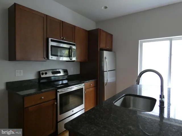 a kitchen with granite countertop a stove and a microwave oven