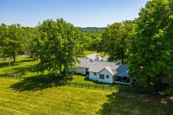 a aerial view of a house with swimming pool next to a big yard