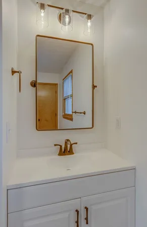 a bathroom with a sink mirror and vanity