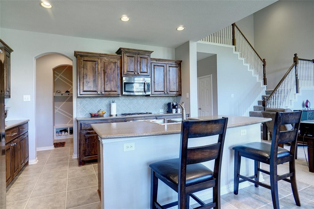 a kitchen with a table chairs microwave and cabinets