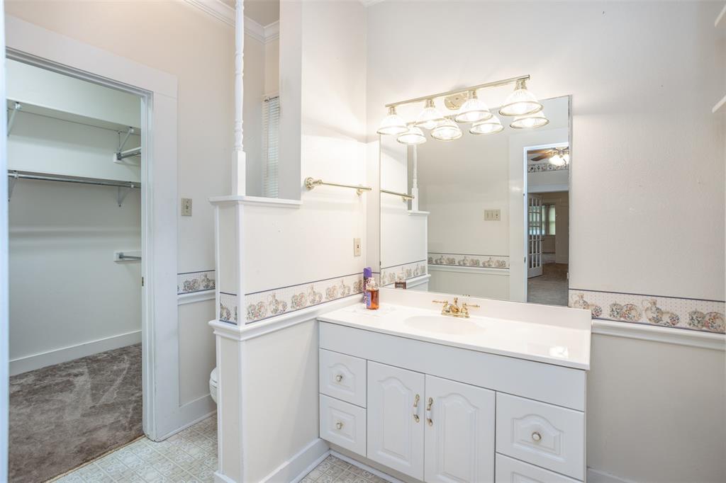 206 Ritchey Street Gainesville, TX 76240 - Photo 21 of 36 a bathroom with a sink and a mirror