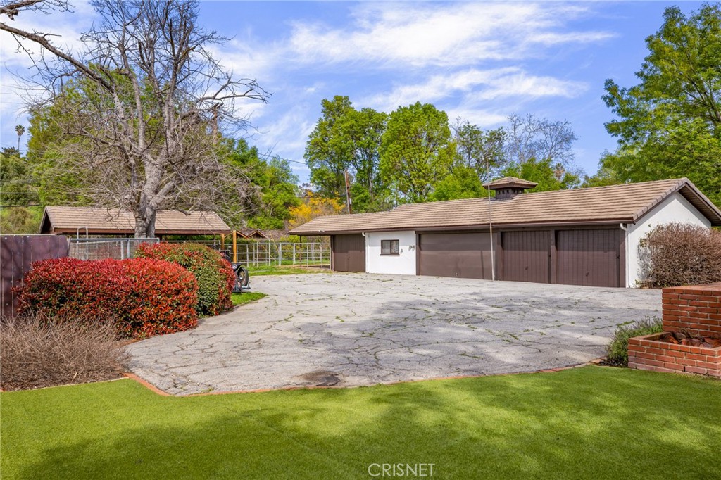 23629 Long Valley Road Hidden Hills, CA 91302 - Photo 17 of 26 a front view of a house with a garden and yard