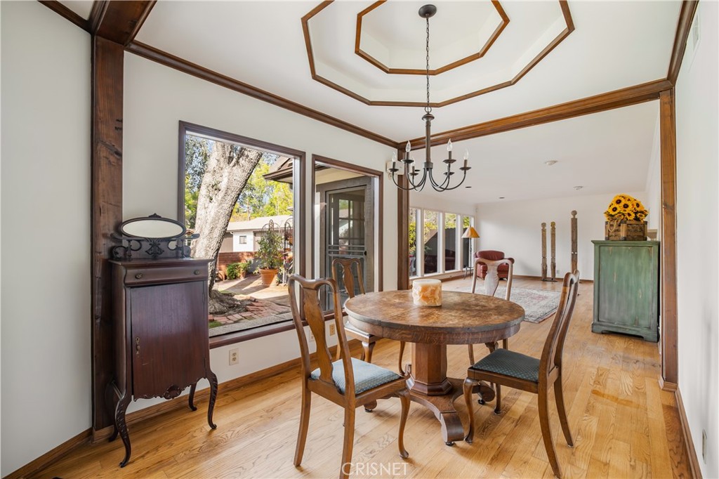 23629 Long Valley Road Hidden Hills, CA 91302 - Photo 6 of 26 a dining room with furniture a chandelier and wooden floor