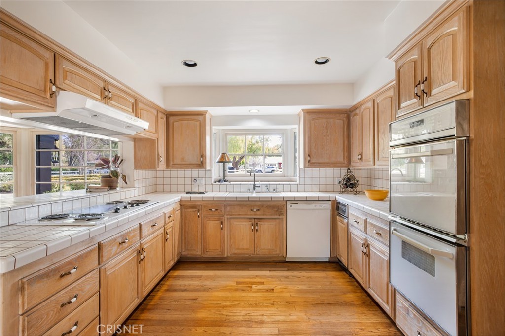 23629 Long Valley Road Hidden Hills, CA 91302 - Photo 8 of 26 a large kitchen with stainless steel appliances granite countertop a lot of counter space and wooden floors