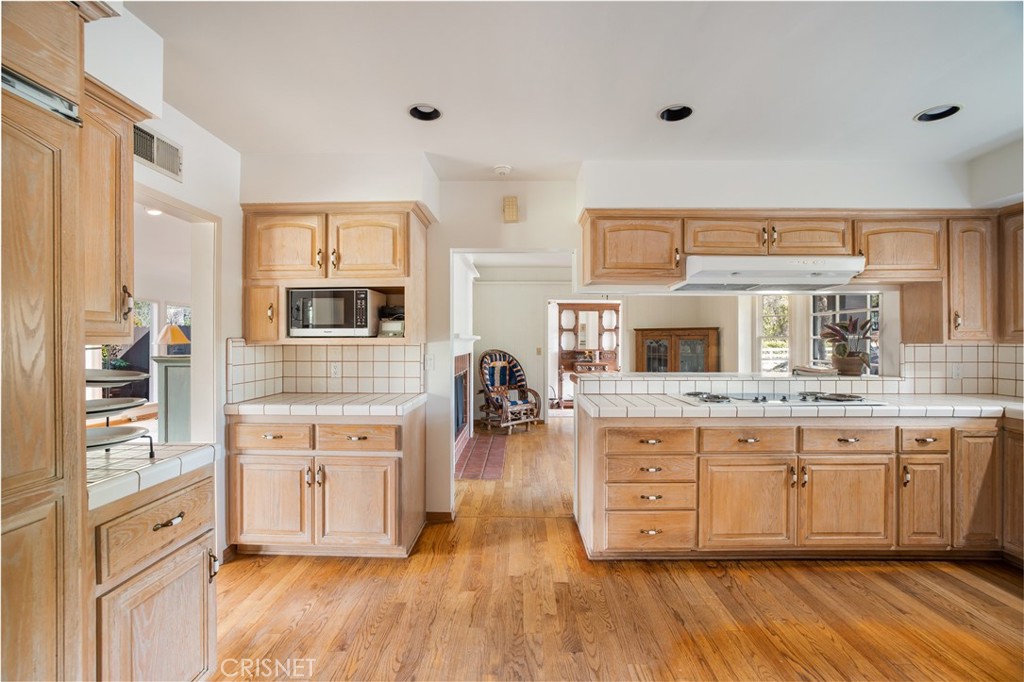23629 Long Valley Road Hidden Hills, CA 91302 - Photo 9 of 26 a kitchen with stainless steel appliances granite countertop a stove and wooden cabinets