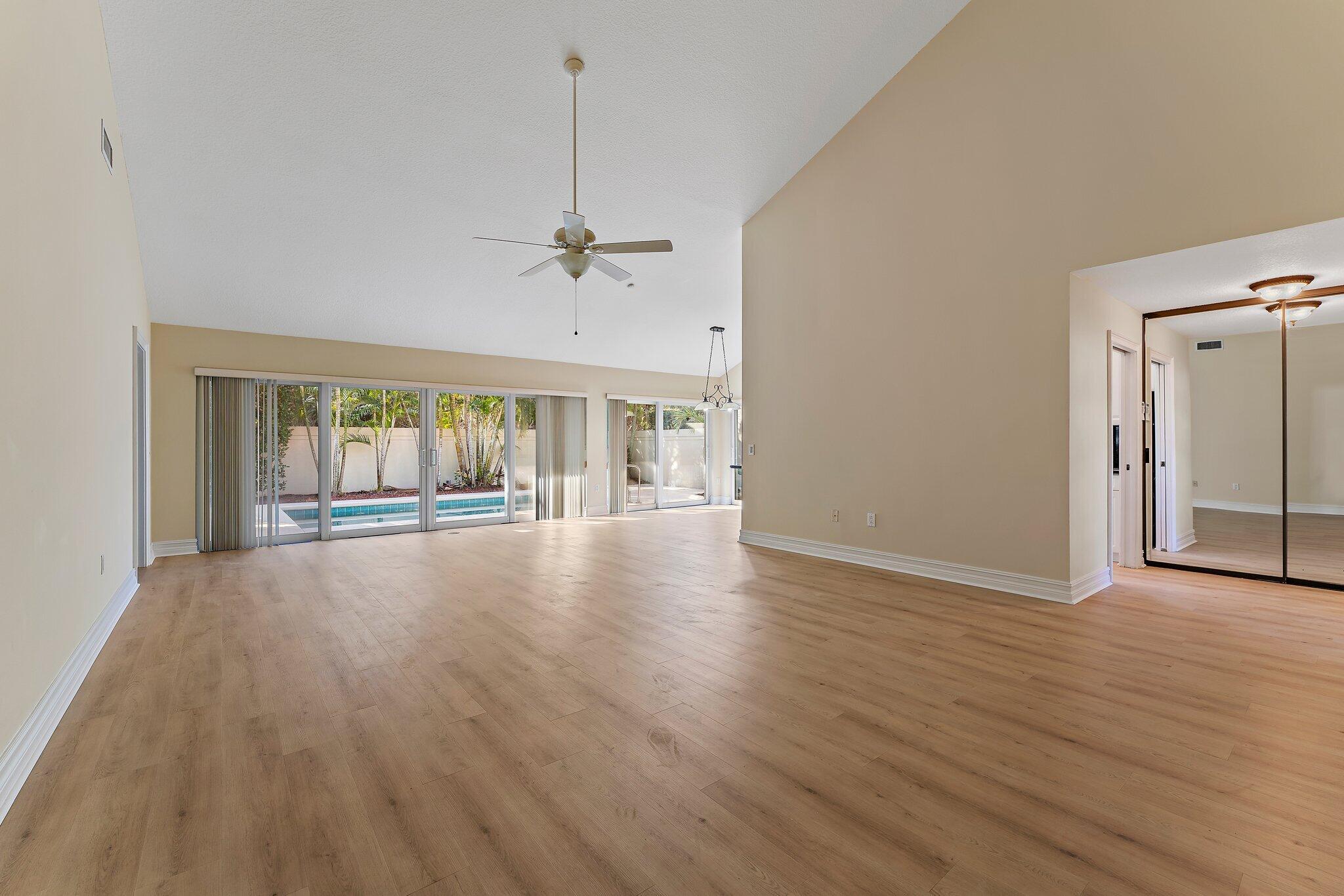 118 Knoll Way Jupiter, FL 33477 - Photo 12 of 40 a view of an empty room with wooden floor and a window