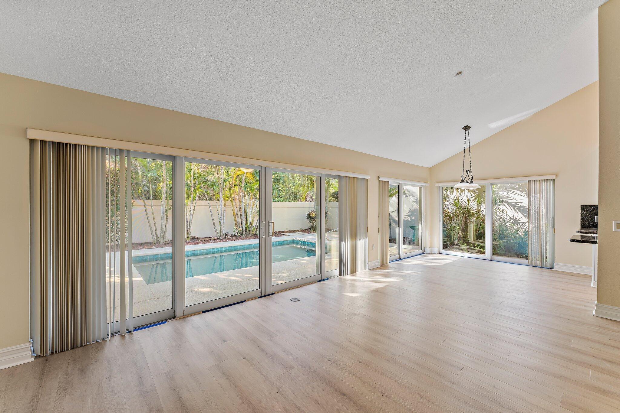 118 Knoll Way Jupiter, FL 33477 - Photo 13 of 40 a view of an empty room with wooden floor and a window