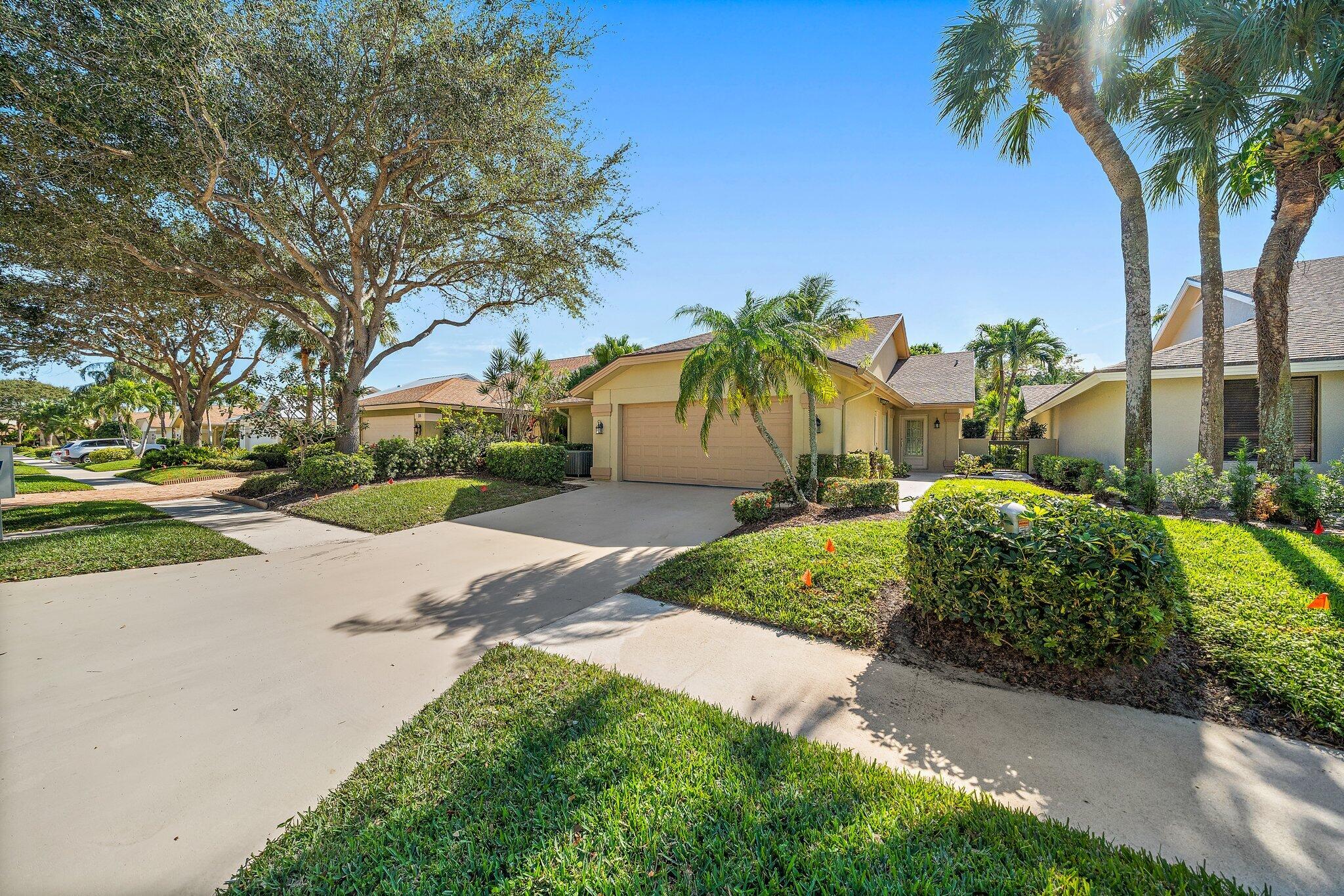 118 Knoll Way Jupiter, FL 33477 - Photo 2 of 40 a front view of a house with garden and a tree