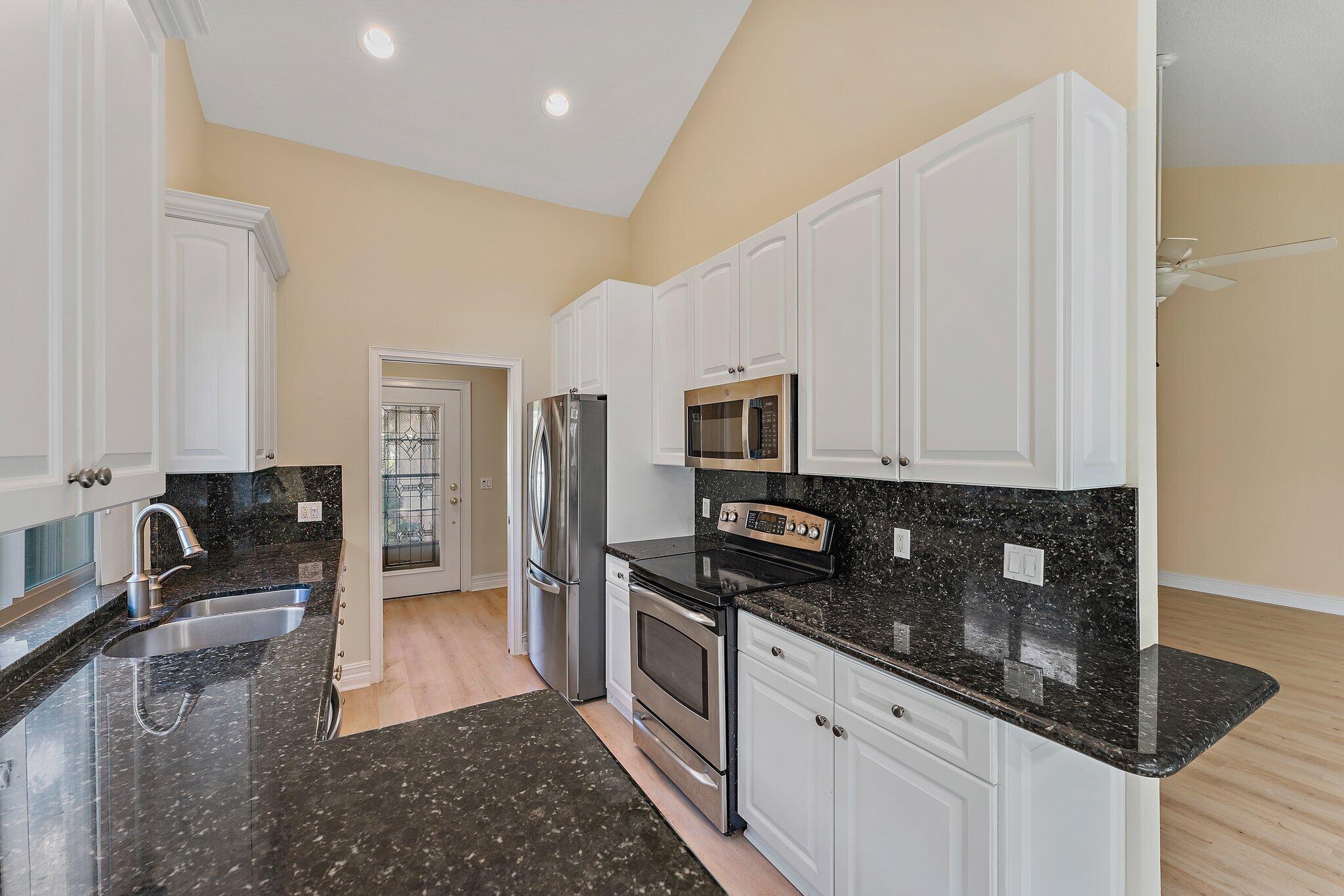 118 Knoll Way Jupiter, FL 33477 - Photo 22 of 40 a kitchen with stainless steel appliances granite countertop a sink stove and cabinets