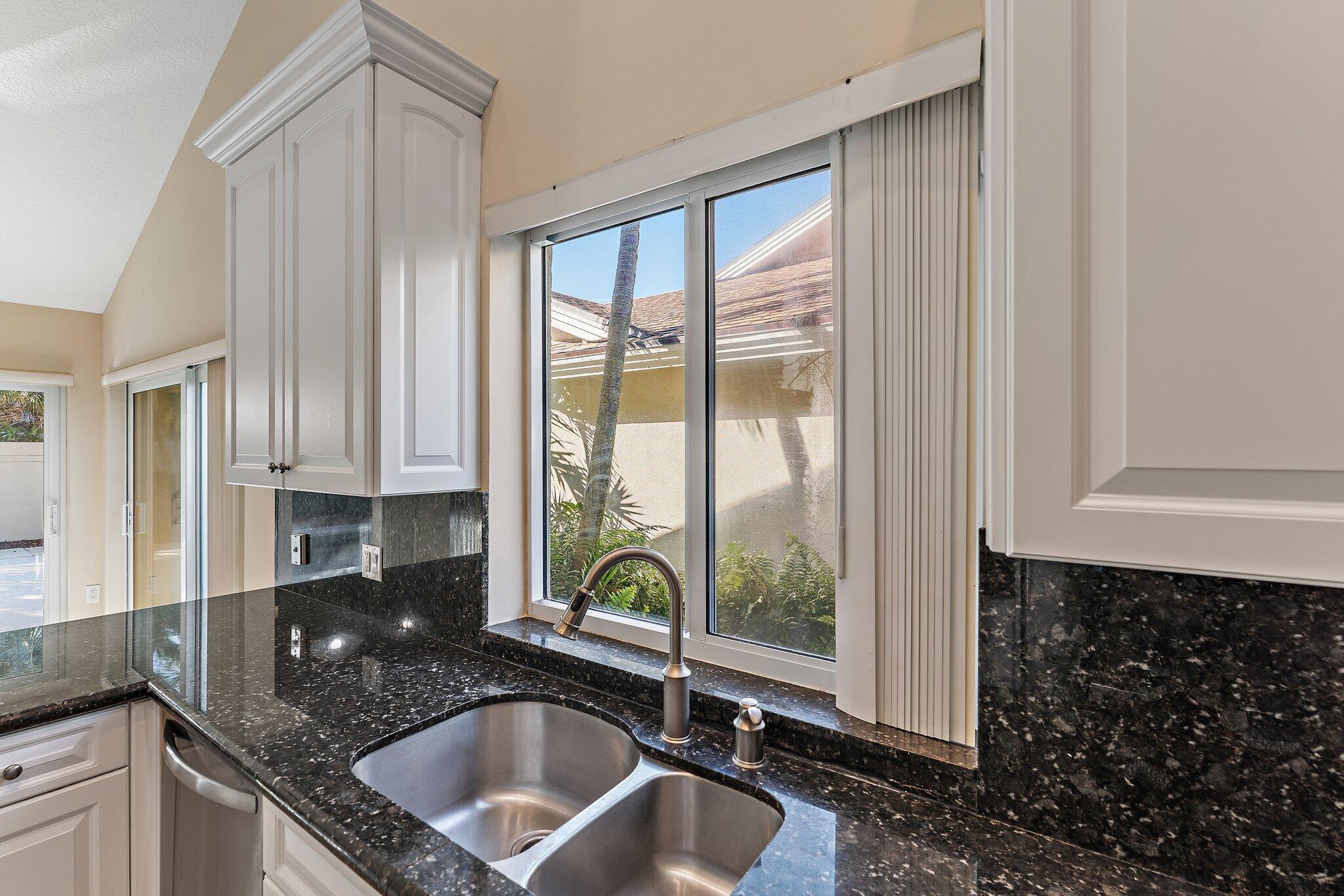 118 Knoll Way Jupiter, FL 33477 - Photo 25 of 40 a kitchen with a sink a counter top space and a large window