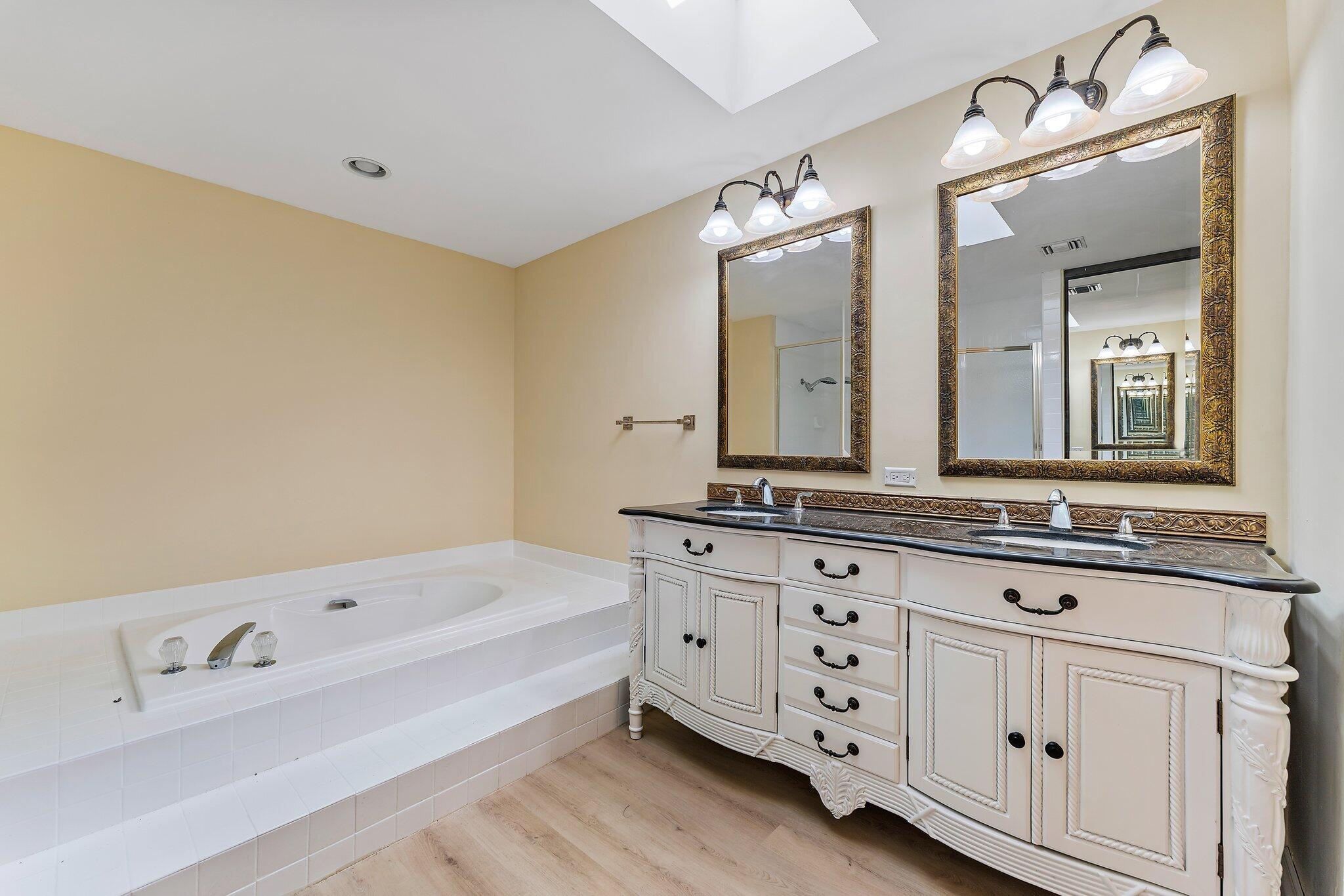 118 Knoll Way Jupiter, FL 33477 - Photo 30 of 40 a bathroom with a bathtub a double vanity sink and mirror