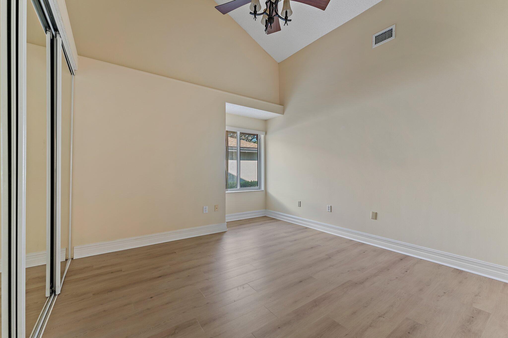 118 Knoll Way Jupiter, FL 33477 - Photo 32 of 40 a view of an empty room with wooden floor and a window