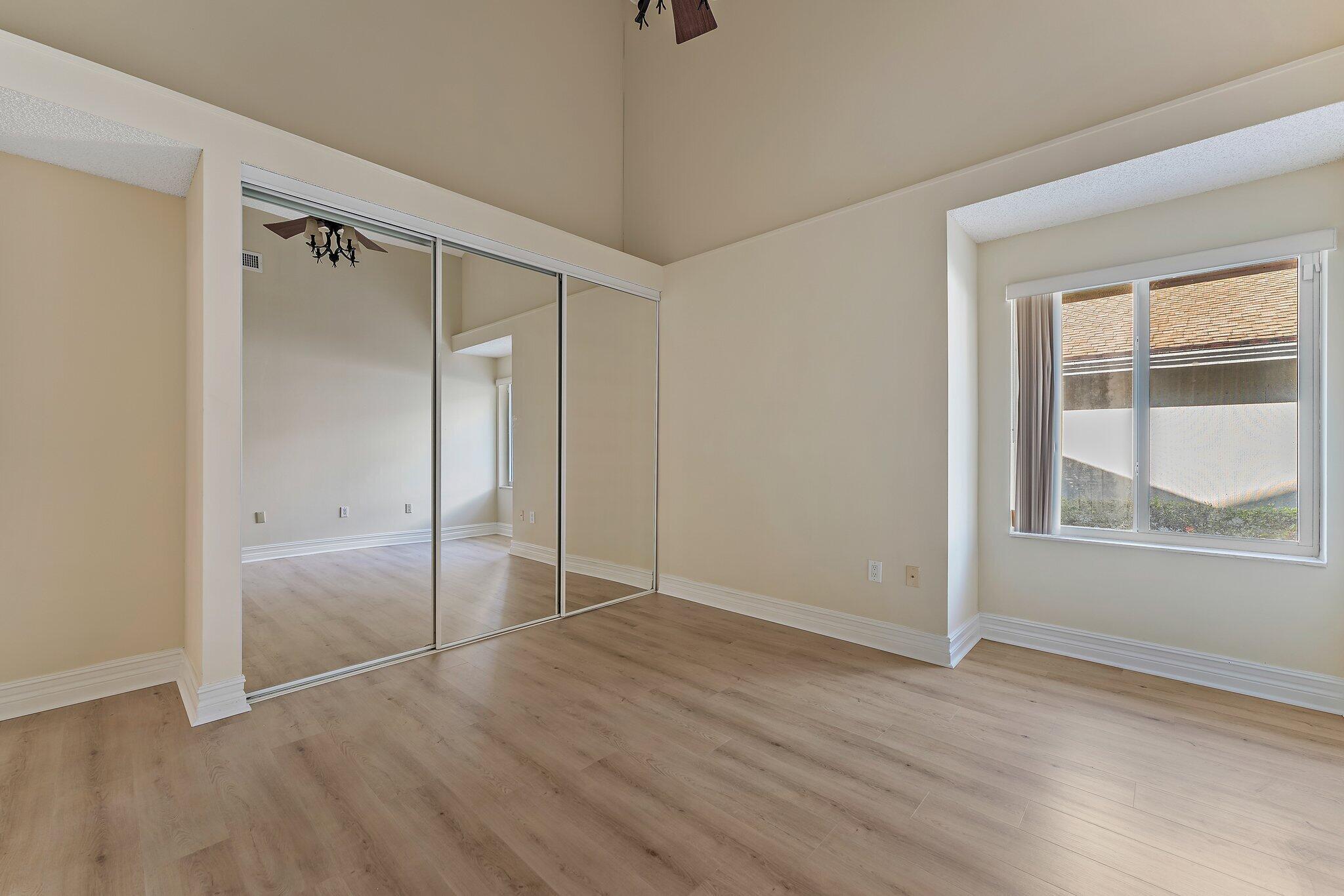 118 Knoll Way Jupiter, FL 33477 - Photo 33 of 40 an empty room with wooden floor and windows
