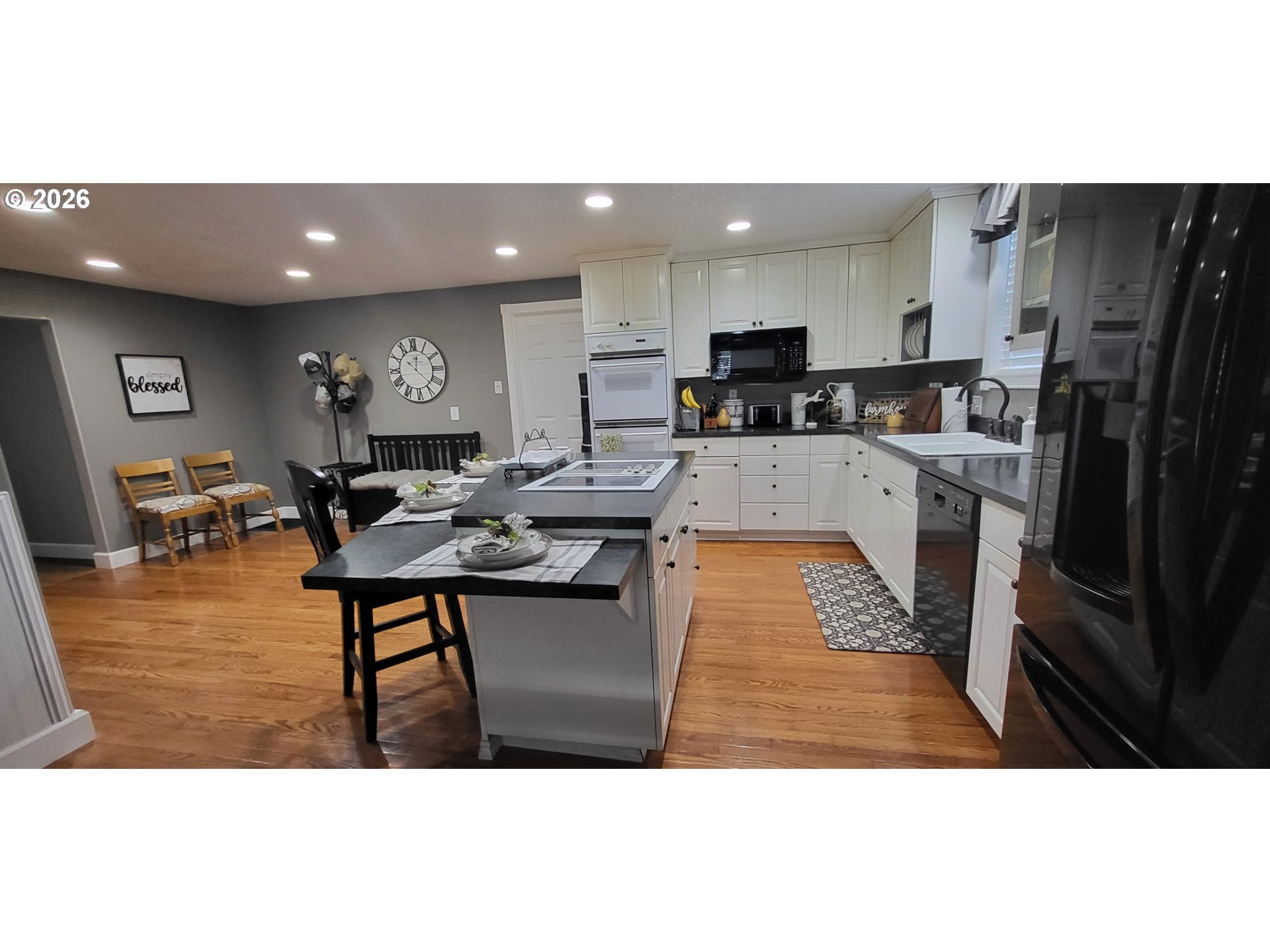 113 Southeast 3rd Avenue Milton Freewater, OR 97862 - Photo 6 of 38 a kitchen with stainless steel appliances kitchen island granite countertop a refrigerator a stove a sink a dining table and chairs with wooden floor