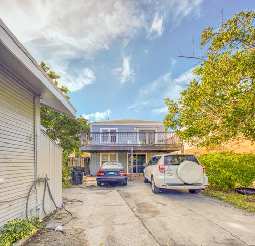 an empty room with wooden floor chandelier and windows