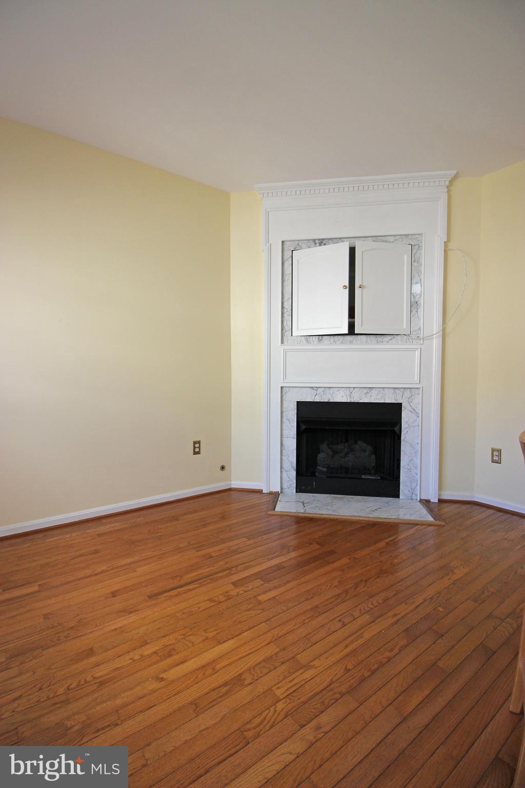 11799 Valley Ridge Circle Fairfax, VA 22033 - Photo 13 of 43 a view of empty room with wooden floor and fireplace