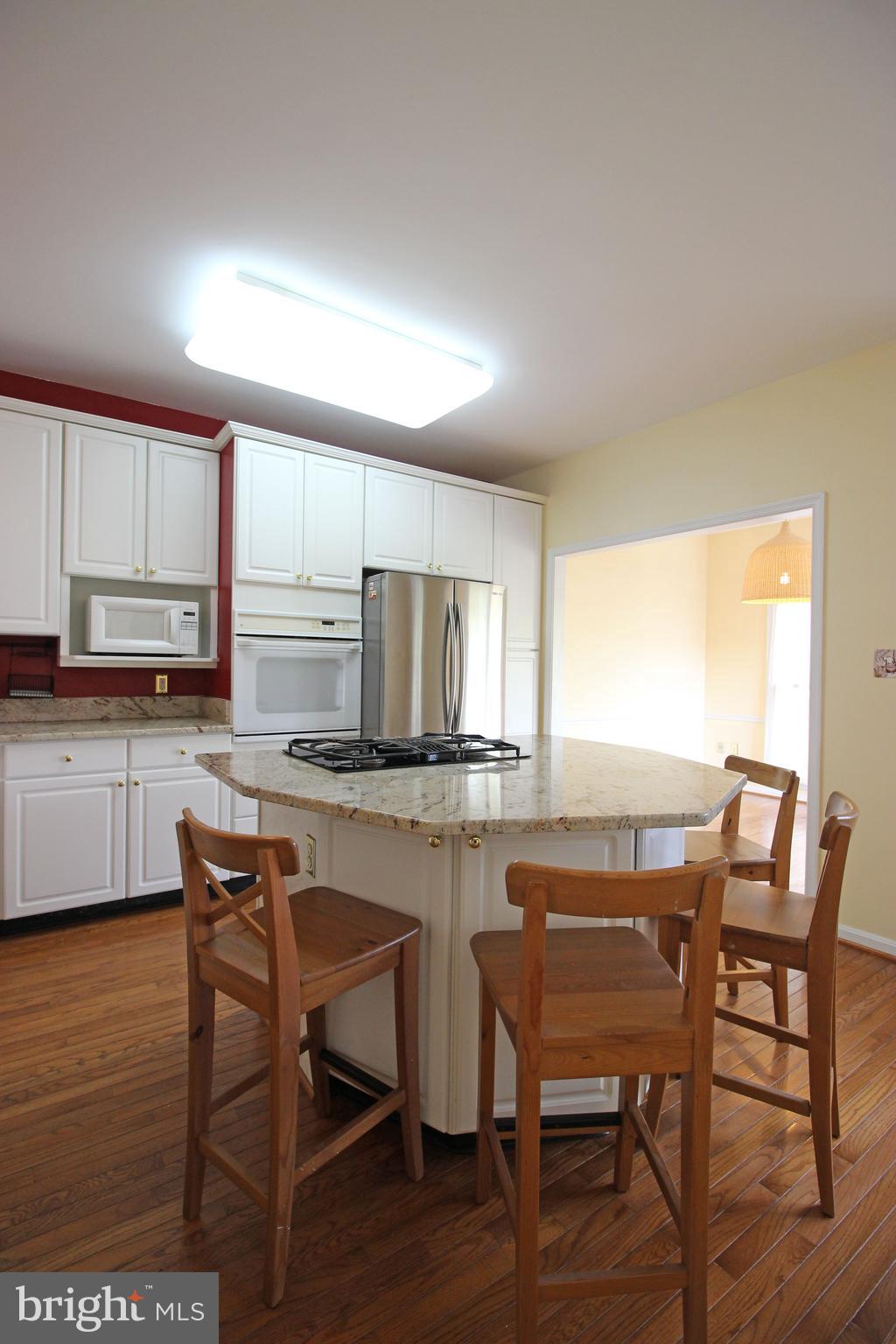 11799 Valley Ridge Circle Fairfax, VA 22033 - Photo 9 of 43 a kitchen with a table chairs microwave and cabinets