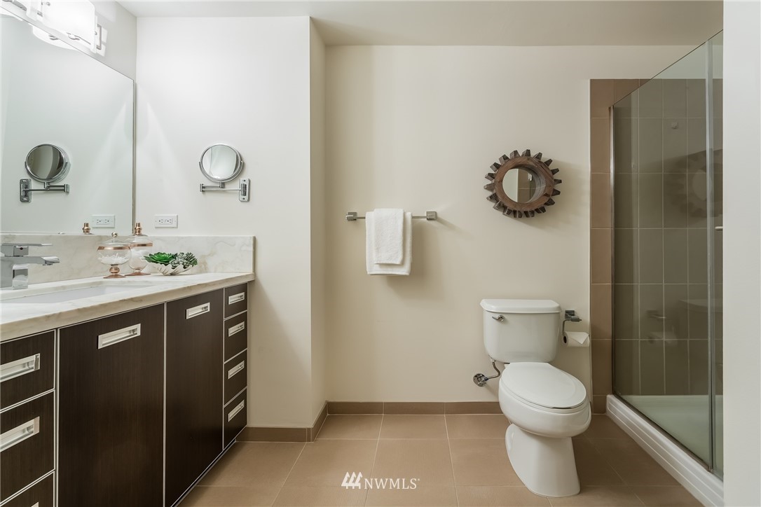 2911 2nd Avenue, Unit 903 Seattle, WA 98121 - Photo 15 of 25 a bathroom with a sink mirror and toilet