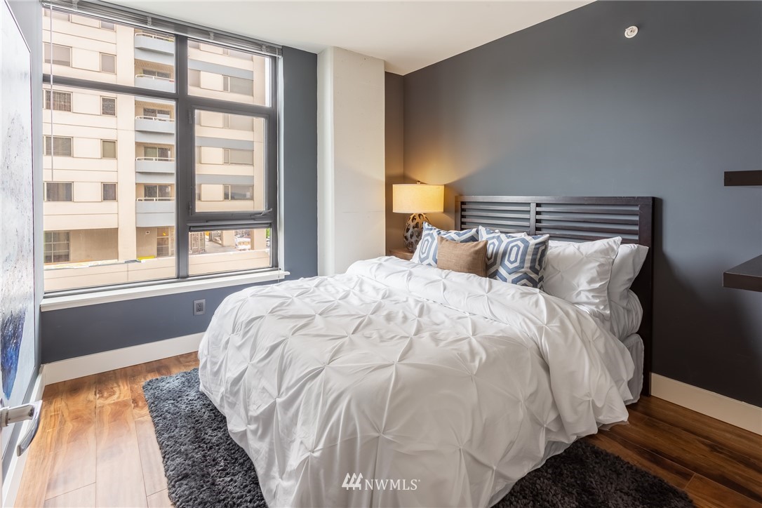 2911 2nd Avenue, Unit 903 Seattle, WA 98121 - Photo 16 of 25 a large bed sitting in a bedroom next to a window