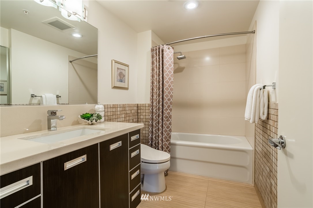 2911 2nd Avenue, Unit 903 Seattle, WA 98121 - Photo 17 of 25 a bathroom with a granite countertop sink toilet and shower
