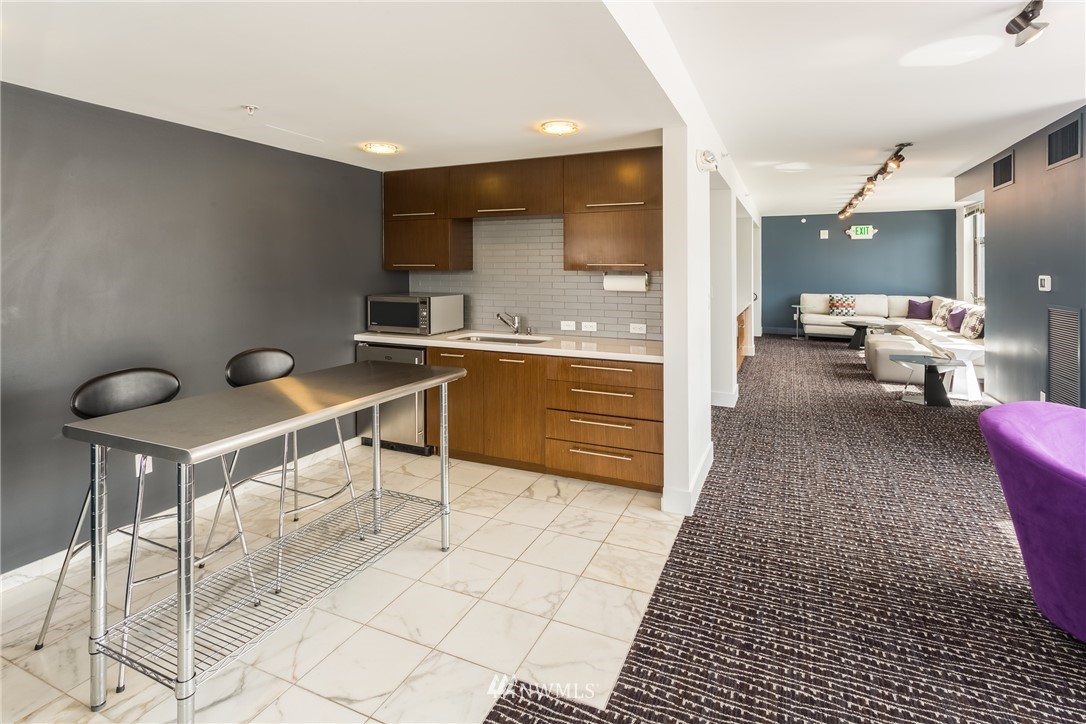 2911 2nd Avenue, Unit 903 Seattle, WA 98121 - Photo 18 of 25 a view of kitchen with sink dining table and chairs