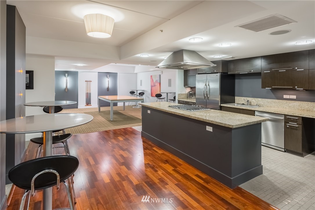 2911 2nd Avenue, Unit 903 Seattle, WA 98121 - Photo 20 of 25 a kitchen with stainless steel appliances granite countertop a sink counter space and cabinets