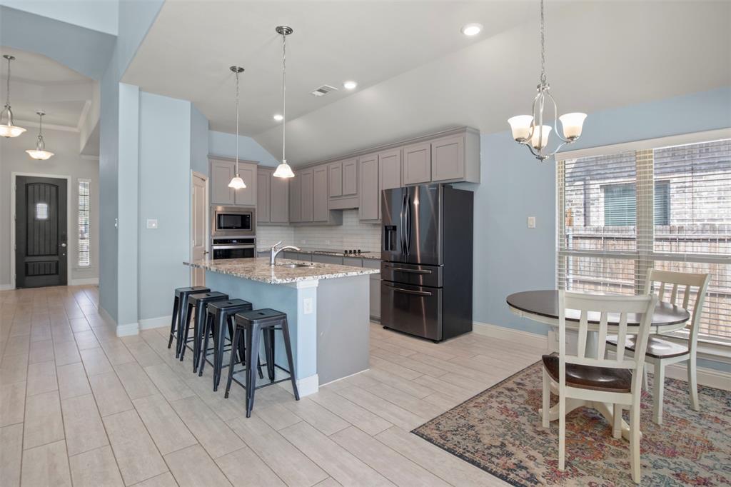 4002 Magnolia Ridge Drive Melissa, TX 75454 - Photo 3 of 36 a kitchen with granite countertop a refrigerator oven a sink a dining table and chairs